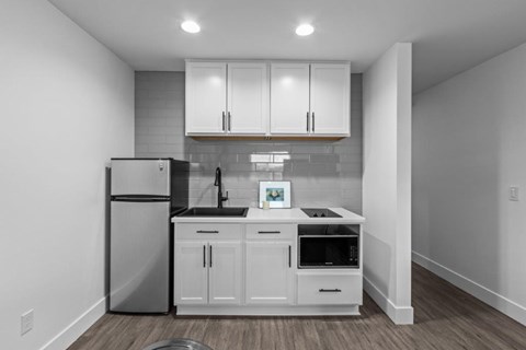 a kitchen with white cabinets and a refrigerator